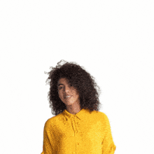 a woman in a yellow shirt is waving in front of a mkrs logo