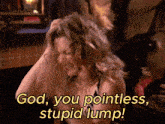 a woman says " god you pointless stupid lump " in yellow letters