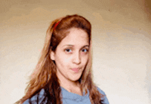 a woman wearing a blue shirt and a red headband looks at the camera .