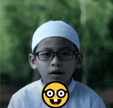 a young boy wearing glasses and a white hat has a yellow smiley face covering his mouth
