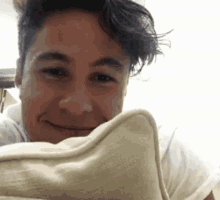 a close up of a man 's face with a pillow in front of him