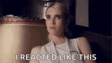 a woman in a white dress is sitting in front of a mirror and says `` i reacted like this '' .