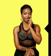 a woman in a black crop top with spikes on it