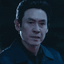 a man in a blue jacket looks at the camera