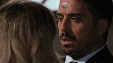 a man with a spinning wheel on his face looks at a woman
