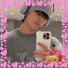 a man wearing headphones takes a picture of himself in a mirror