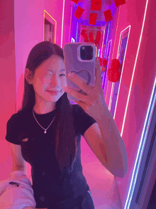 a girl is taking a picture of herself in a pink room