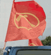 a red flag with a hammer and sickle on it is flying in the wind