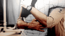 a man wearing a watch is hugging a woman who is wearing a plaid shirt