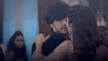 a man and a woman are dancing together in a room in a dark room .
