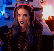 a woman with blue hair is wearing headphones and a black top