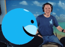 a man wearing headphones is playing drums in front of a blue ball