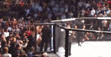 a man is standing in a boxing ring in front of a crowd .