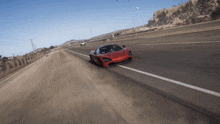 a red sports car is driving down the road