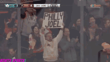 a fan holds up a sign that says philly joel during a hockey game