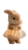 a stuffed bunny wearing a feathered skirt with lights on it