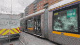 a luas van is parked next to a train with broken windows