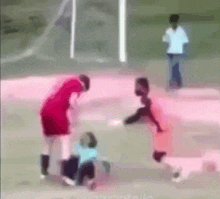 a group of people are playing soccer on a field and one of the players is wearing a red shirt .