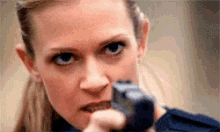 a close up of a woman pointing a gun