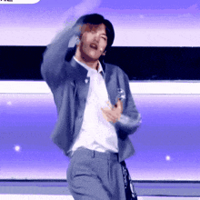 a man in a suit and tie is dancing on stage
