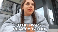 a girl with braids says that was really good in front of a balcony