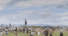 a group of people are standing in a field with a giant inflatable animal in the background