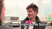 a man is talking into a microphone with the words ik schijt wel ergens in de bossies written below him