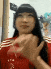 a girl with long black hair is wearing a red shirt with white stripes