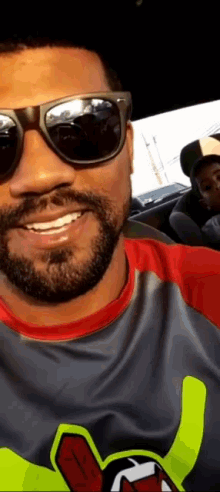 a man with a beard wearing sunglasses and a shirt that says ' a ' on it
