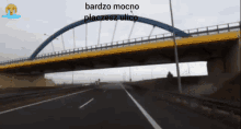 a bridge over a highway with the words bardzo mocno placesz ulico