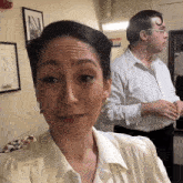 a man and a woman are standing next to each other in a hallway with a sign that says no smoking