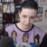 a woman is wearing a purple shirt with a picture of a group of women on it .