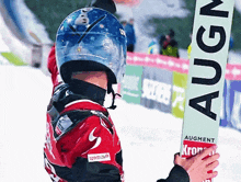 a person wearing a helmet is holding a sign that says augment