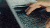 a close up of a person typing on a laptop keyboard .
