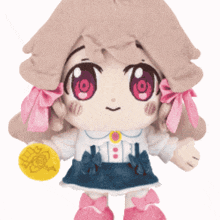 a stuffed doll with pink ribbons on her hair