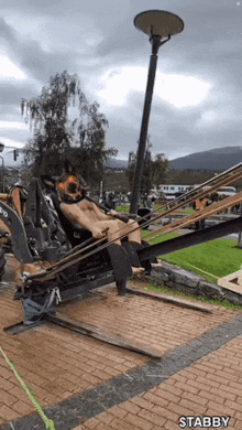 a man is laying on a machine that says volvo on it .