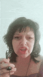 a woman is holding a pair of ear buds and making a face