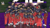 a group of players wearing qatar shirts pose for a photo
