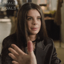a woman is giving a high five with the words small achievable goals above her