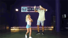 a man and a little girl are dancing together on a stage in a dance studio .