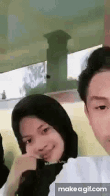 a man and a woman are sitting next to each other and smiling