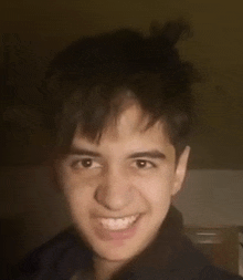 a young man with a bun in his hair is smiling for the camera