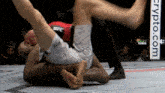 two men are wrestling in a cage with a crypto.com banner in the background
