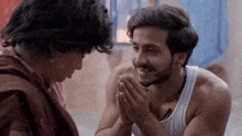a man and a woman are sitting next to each other and holding hands .