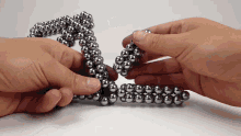 a person is holding a string of metal beads in their hands