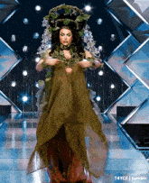 a woman is walking down a runway wearing a green and red dress