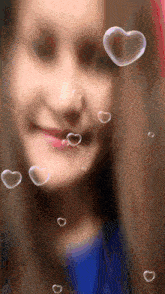 a girl with soap bubbles in the shape of hearts around her