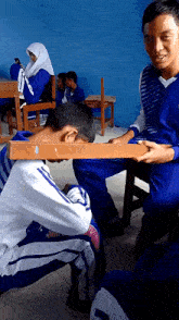 a boy in a blue and white striped shirt kneeling down