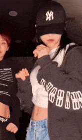 a girl wearing a ny hat and a crop top
