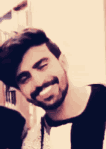 a man with a beard and mustache is smiling for the camera